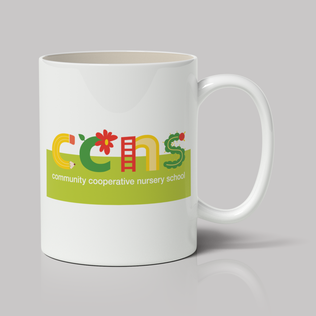 A mug featuring a colorful logo for the Community Cooperative Nursery School. The design includes playful letters with a flower, ladder, and caterpillar integrated into the text on a green background.
